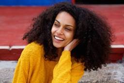Woman with beautiful curly hair smiling on a fall day