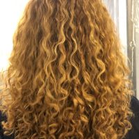 Women's long gold curly hairstyle by Leslie Ellen Curly Hair Salon NYC