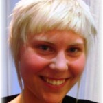 woman with short, platinum blonde hair smiling at the camera after makeover