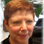 A woman with short dark red hair in salon after makeover