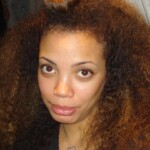 A close-up of a woman with voluminous, curly hair before haircut