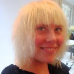 A woman with short, bleached blonde hair smiling before makeover