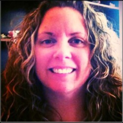 A woman with wavy hair smiling at the camera