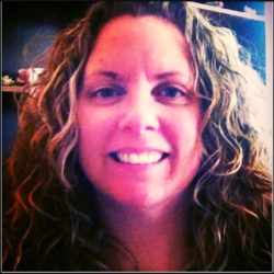 A woman with wavy hair smiling at the camera